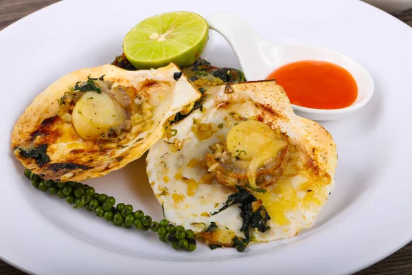 Ispanak, limon ve beyaz plaka üzerinde peynir ile pişmiş tarak