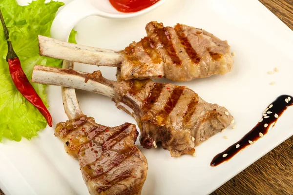 Salata yaprakları ahşap arka plan üzerinde hizmet domates soslu kuzu ızgara