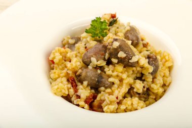 Bulgur tavuk kalpleri ve ahşap arka plan üzerinde kuru domates ile kase