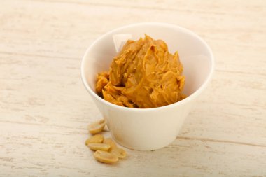 Ahşap arka plan üzerinde fındık fıstık ezmesi kase