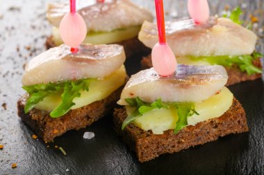 Kanepe ringa balığı ve ahşap arka plan üzerinde patates ile