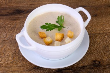 Ahşap arka plan üzerine maydanoz ile mantar kremalı çorba