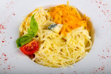 Makarna dört peynir basil beyaz tabakta