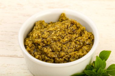 Fesleğenli pesto sos kapta ahşap arka plan üzerinde bırakır.