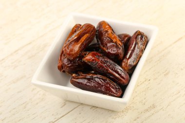 Tatlı meyve yığın kase ahşap arka plan üzerinde tarihleri.