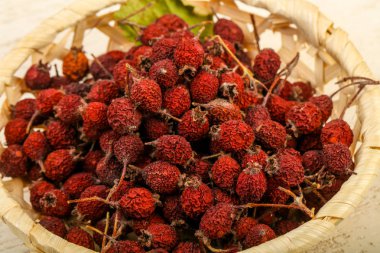 Kase ahşap arka plan üzerinde kuru alıç yığın 