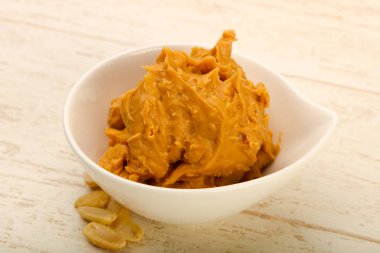 Ahşap arka plan üzerinde fındık fıstık ezmesi kase