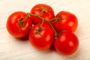 Ahşap arka plan üzerinde olgunlaşmış domates şube