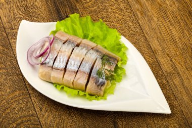 Ahşap arka plan üzerinde ringa balığı filetosu dereotu ve soğan dilimlenmiş