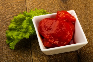 Kase ahşap arka plan içinde suyu ile soyulmuş domates