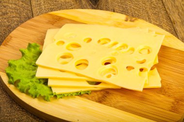 Ahşap arka plan üzerinde dilimlenmiş peynir salata yaprakları