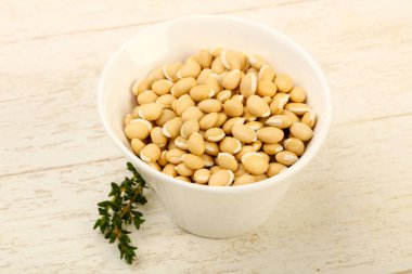 Ahşap arka plan üzerinde kapta çiğ beyaz fasulye