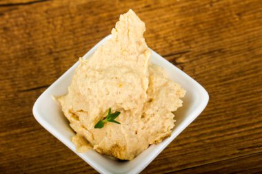 Susam ve kekik ile vejetaryen Humus ahşap arka plan üzerinde bırakır