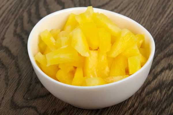 Ahşap arka plan üzerinde kase Konserve ananas