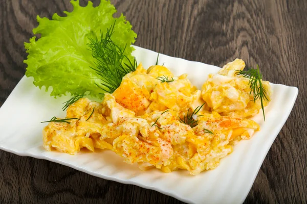 Ahşap arka plan üzerinde beyaz tabak içinde pişmiş yumurta