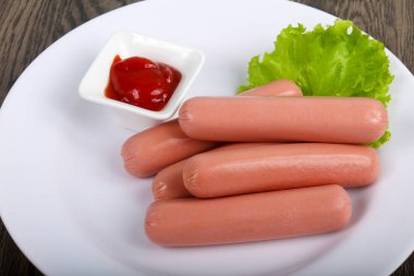 Salata ve ahşap arka plan üzerine ketçap ile sosis haşlama