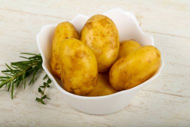 Ahşap arka plan üzerinde otlar ile ham genç patates
