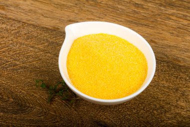 Kase çiğ polenta ahşap arka plan üzerinde yemek pişirmek için hazır