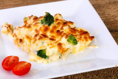 Beyaz tabak içinde peynirli fırında lahana