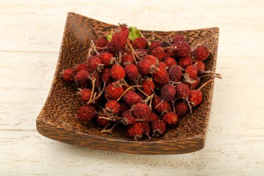 Kase ahşap arka plan üzerinde kuru alıç yığın