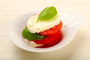 İtalyan Caprese salatası beyaz plaka üzerinde