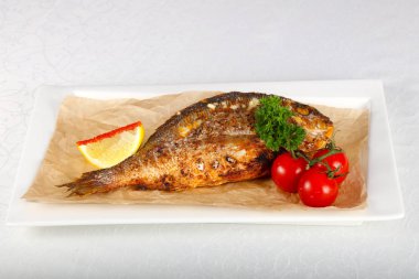 Dorada balık beyaz plaka üzerinde kavrulmuş