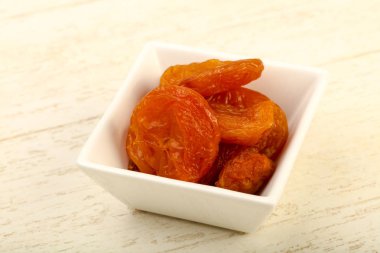 Kuru Kayısı yığın içinde kase ahşap arka plan üzerinde 