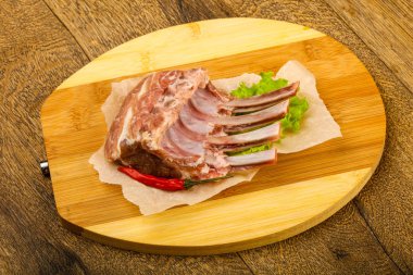 Ham kuzu kaburga ile biber ahşap arka plan üzerinde yemek pişirmek için hazır