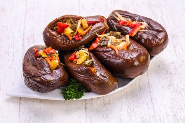 Doldurulmuş patlıcan ve domates salata yaprakları ahşap arka plan üzerinde servis