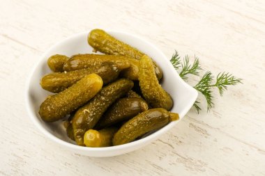 Ahşap arka plan üzerinde kaseye Picled salatalık