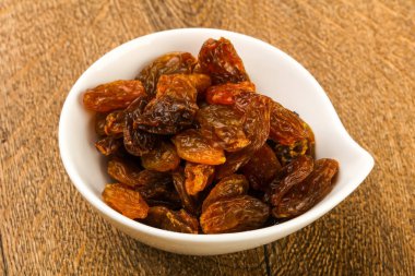 Ahşap arka plan üzerinde kase kuru kuru üzüm