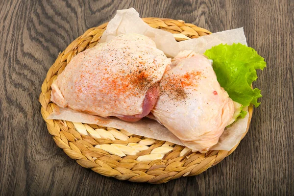 Raw chicken thighs ready for cooking over wooden background