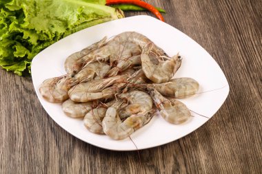 Ham Kral ahşap arka plan üzerinde yığın kase karides