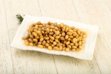 Kasedeki fasulyeler ahşap arka planda. 