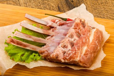 Ham kuzu kaburga ile biber ahşap arka plan üzerinde yemek pişirmek için hazır