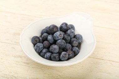 Yaban mersini kase ahşap arka plan üzerinde