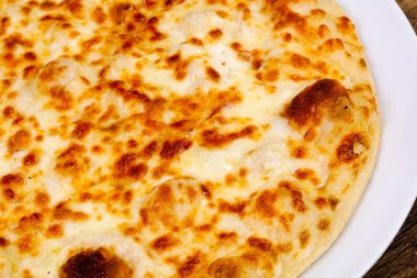 Ahşap arka plan üzerinde sıcak lezzetli peynirli pizza