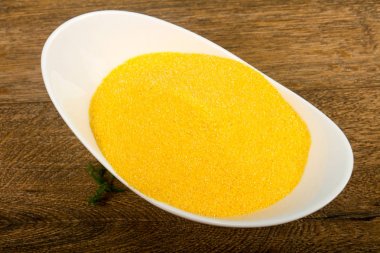 Polenta ahşap arka plan üzerinde kase kuru domates ile