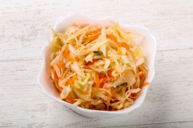 Raw pickled cabbage on wood background clipart