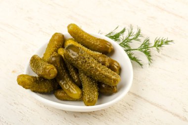 Ahşap arka plan üzerinde kaseye Picled salatalık