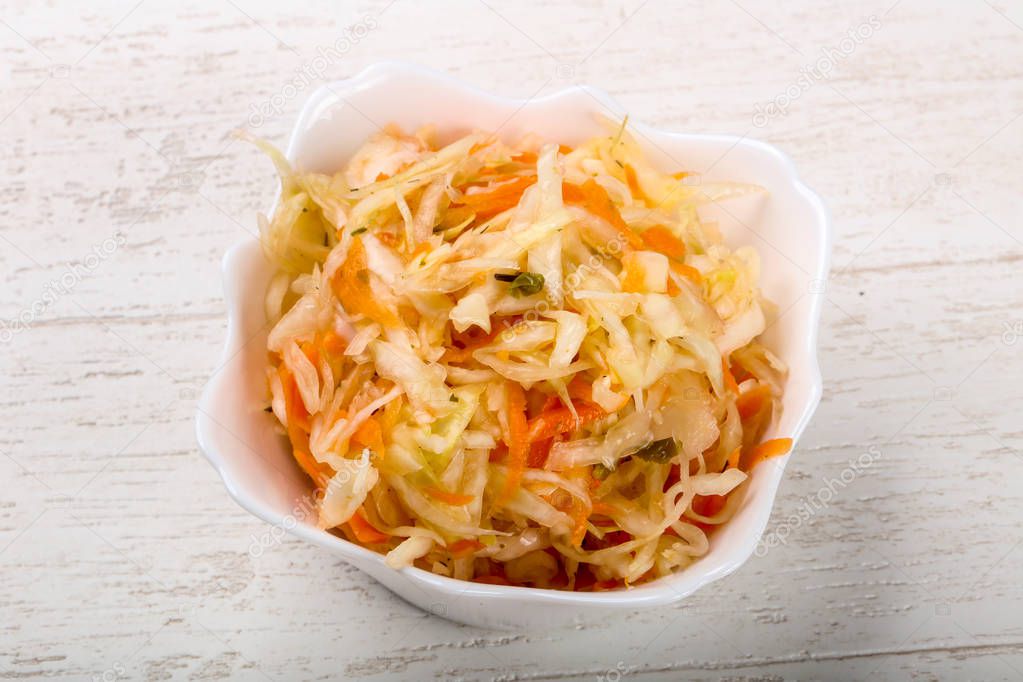 Raw pickled cabbage on wood background