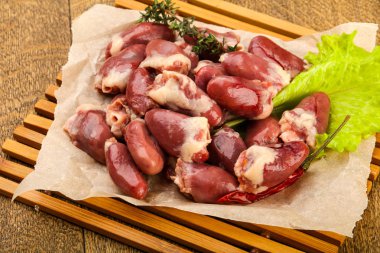 Çiğ tavuk kalpleri marul üzerinde ahşap arka plan vardı