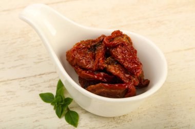 Kurutulmuş domates zeytin yağı fesleğen yaprakları ile