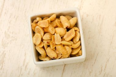 Ahşap arka plan üzerinde kase fıstık yığın