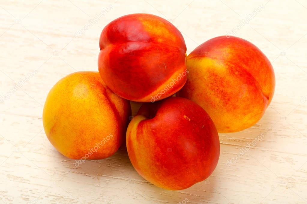 Ripe Nectarines heap over wooden background