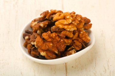 Ahşap arka plan üzerinde kapta ceviz yığın