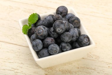 Yaban mersini kase ahşap arka plan üzerinde