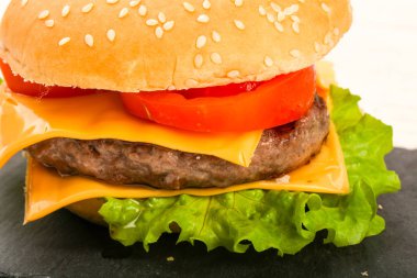Ahşap arka plan üzerinde Burger peynir, domates ve salata yaprakları