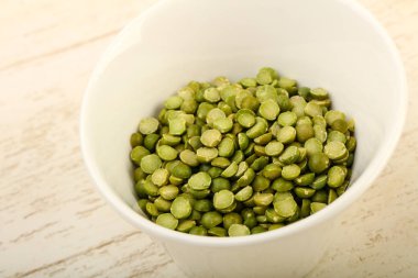 Yeşil bezelye kasede ahşap arka plan üzerinde kazık.