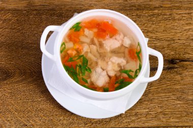 Havuç ve ahşap arka plan üzerinde otlar ile tavuk çorbası